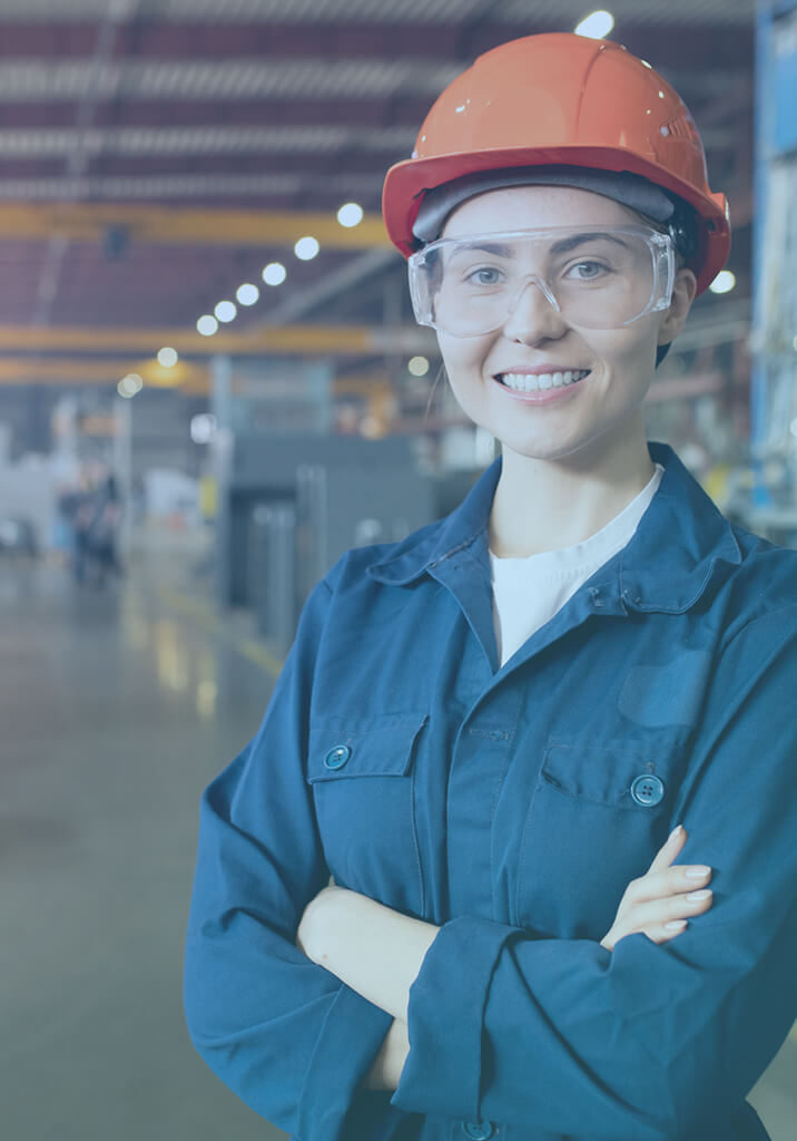 Lady in hard hat and safety glasses and clothes on factory floor